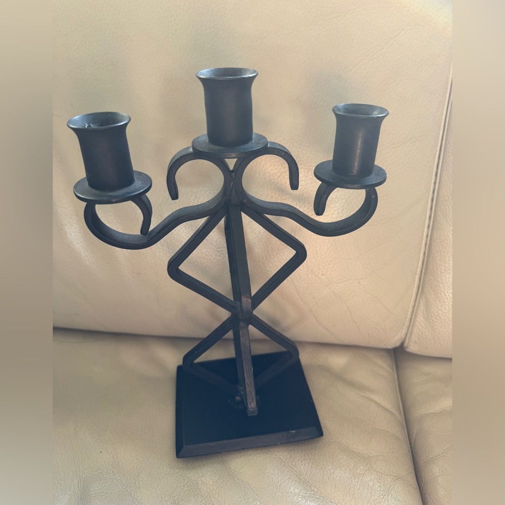 Metal wrought iron candle holder in black.
